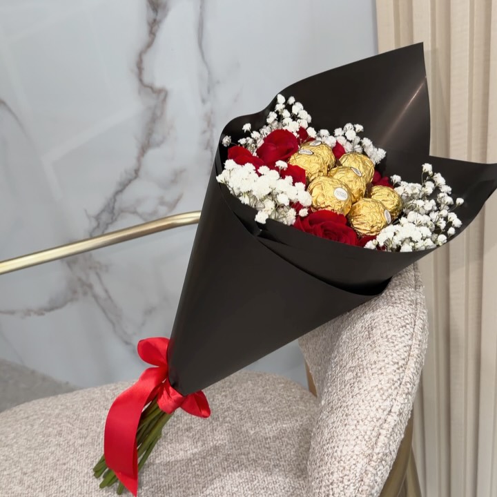 Arreglo de rosas rojas con follaje blanco y detalles dorados, trabajo de Febrero Floral